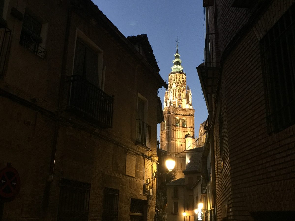 Calle de Toledo al anochecer con la torre de la Catedral iluminada